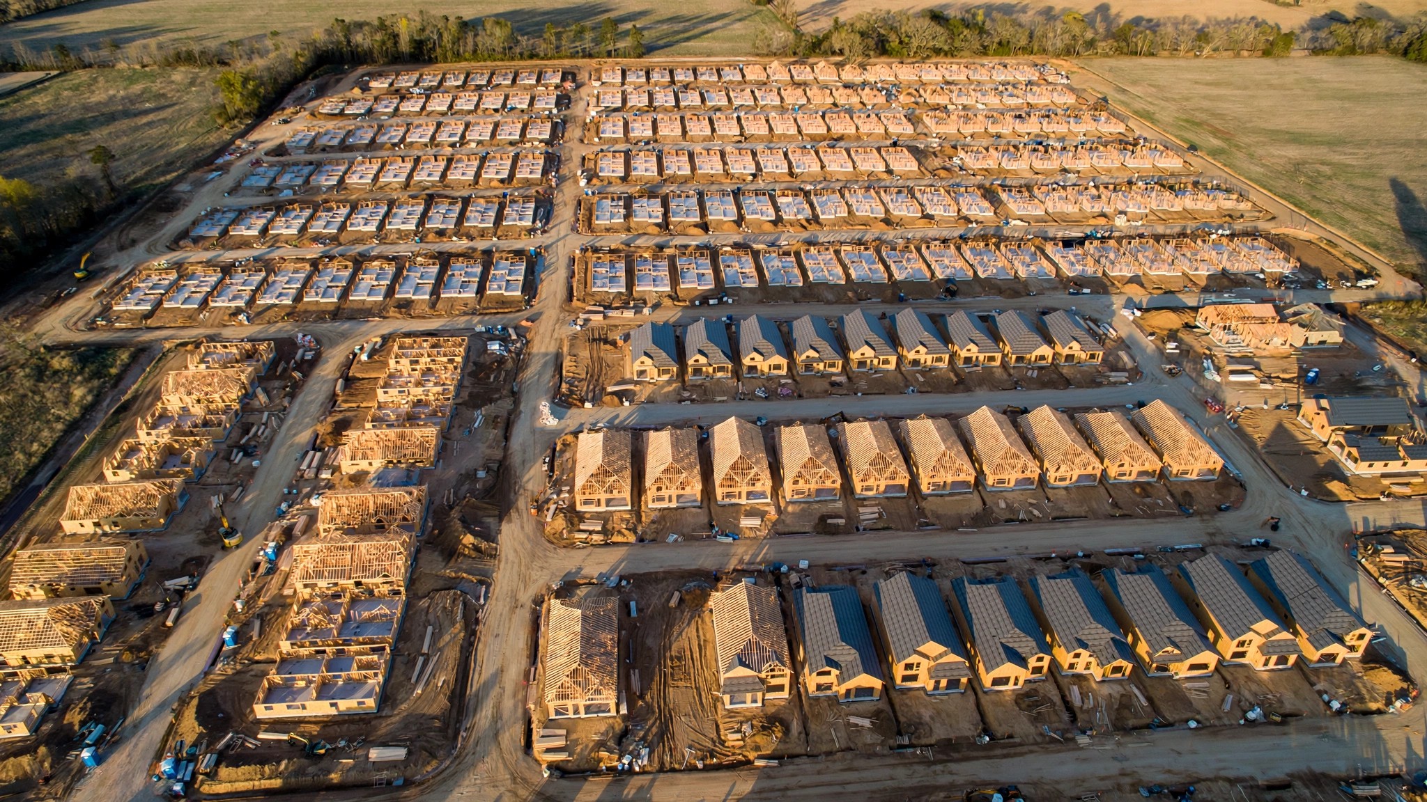 Aerial view of a subdivision where every house shares the same massing, the same roofline, the same relationship to the street, differing only in the color of the siding